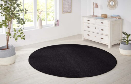 Modern effen vloerkleed rond Nasty - zwart - sfeer